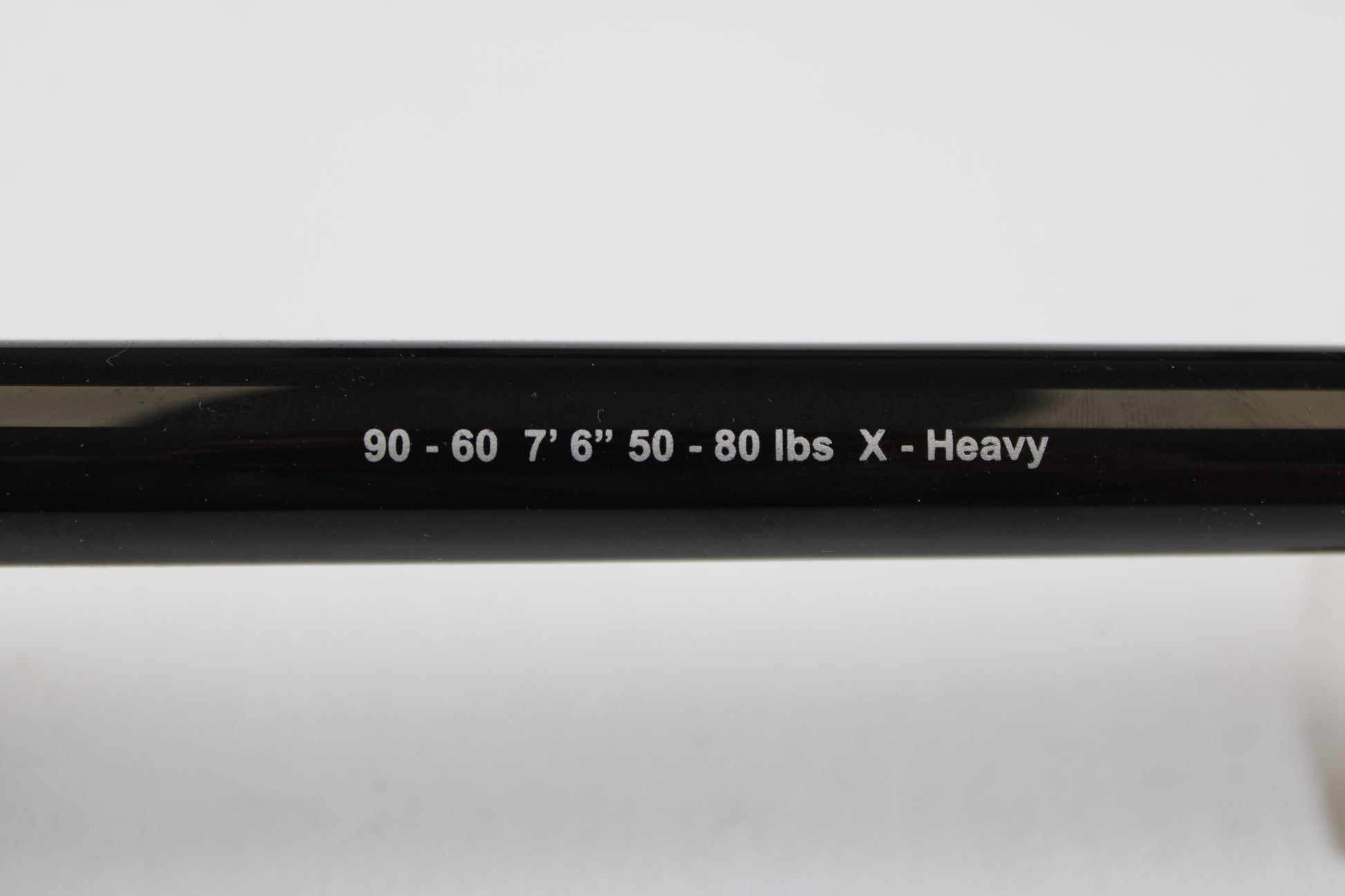 A close-up of a G. Loomis IMX-PRO Offshore 90-60 7'6" XH Used Casting Rod in mint condition, featuring white text on a black finish—ideal for trading in or earning store credit on used G. Loomis gear.