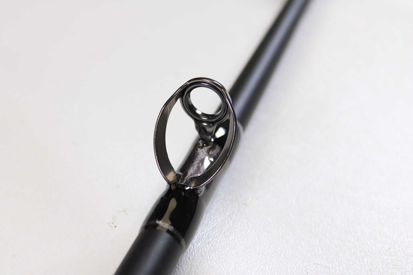 Close-up of the G. Loomis IMX-PRO Offshore 90-60 7'6" XH used casting rod in mint condition, highlighting the metal guide—perfect for anglers exploring quality pre-owned gear or considering our rod and reel trade-in options.