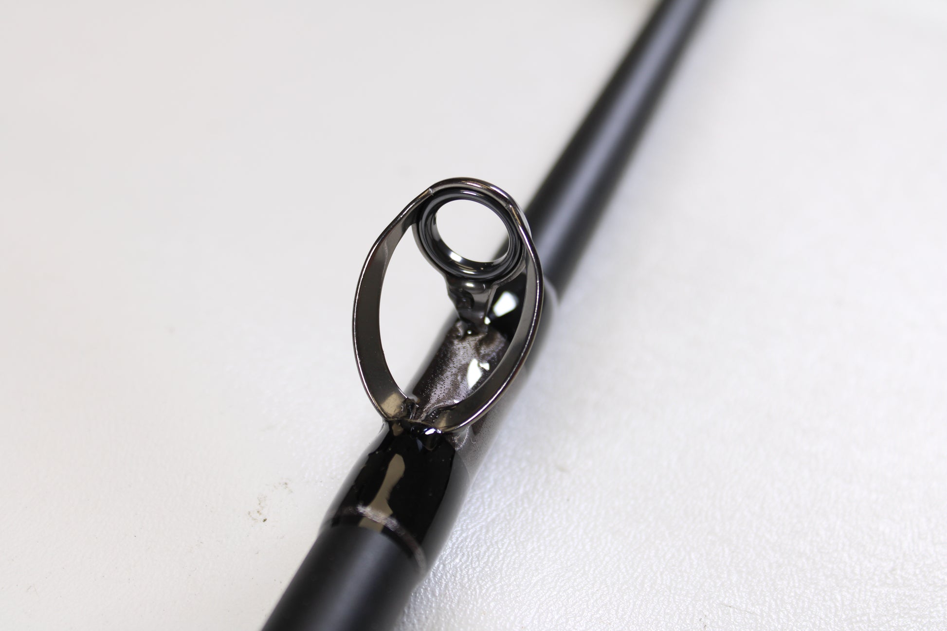 Close-up of the G. Loomis IMX-PRO Offshore 90-60 7'6" XH used casting rod in mint condition, highlighting the metal guide—perfect for anglers exploring quality pre-owned gear or considering our rod and reel trade-in options.