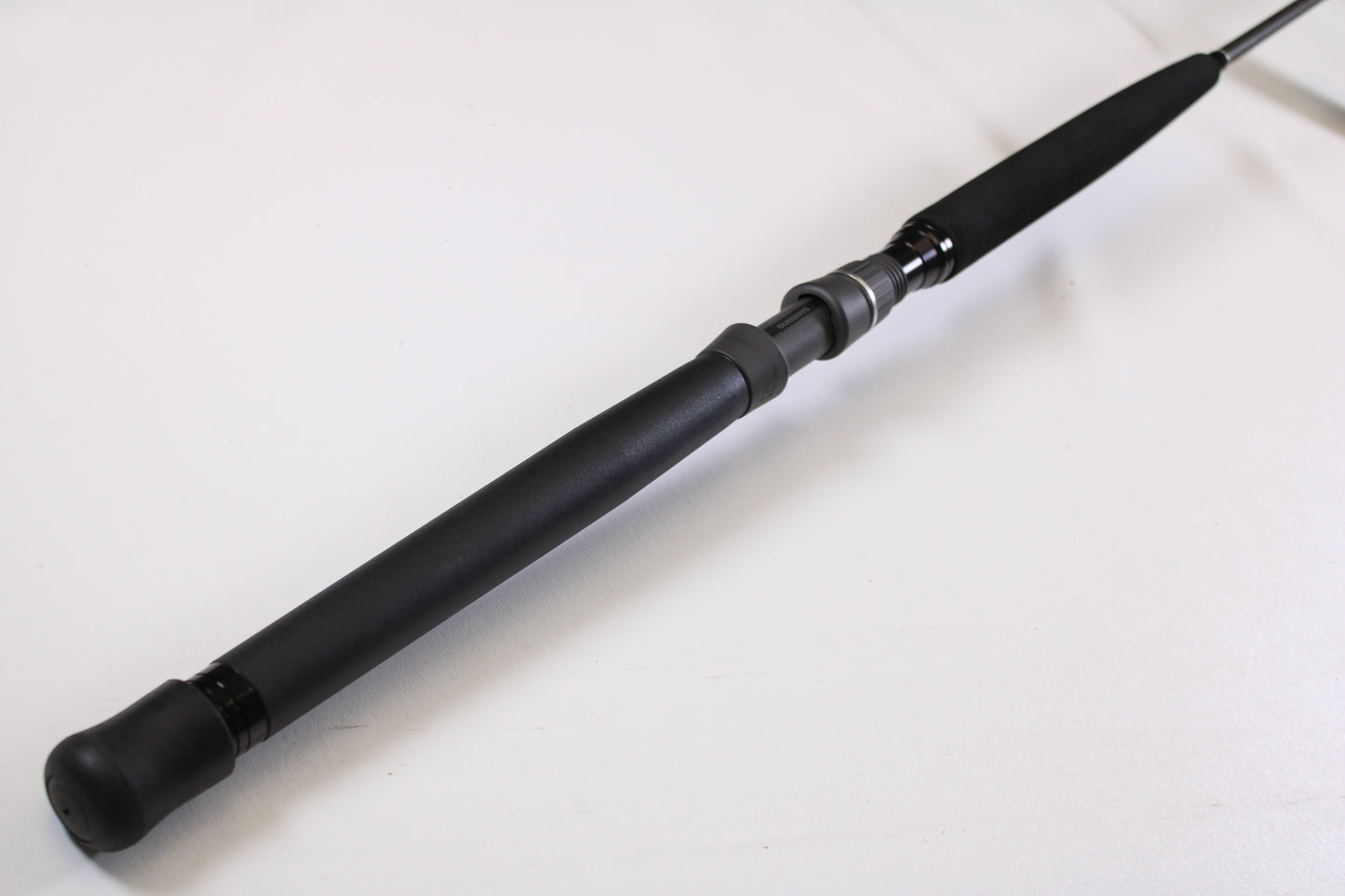 A close-up of the Shimano Terez BW TZBWC70MSBA 7'0" Medium Used Casting Rod’s black foam handle, shown in mint condition against a white background—ideal for our rod and reel trade-in program.