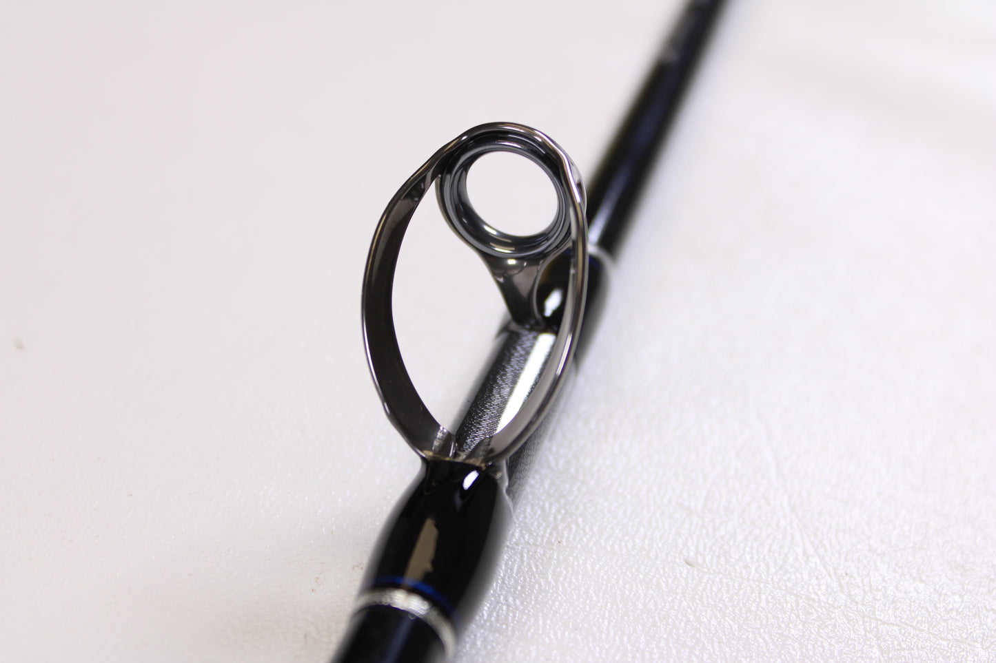 Close-up of the Shimano Terez BW TZBWC70MSBA 7'0" Medium Used Casting Rod's guide ring on a black rod, set against a white background. Mint condition—ideal for anyone seeking quality used Shimano gear.