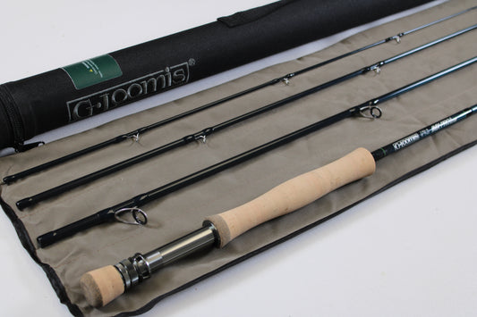 A disassembled G. Loomis IMX-PRO V2S Saltwater 790-4 9'0" #7 Used Fly Rod in mint condition with a cork handle is laid out on a fabric case beside a black tube, both showing the G. Loomis brand name.