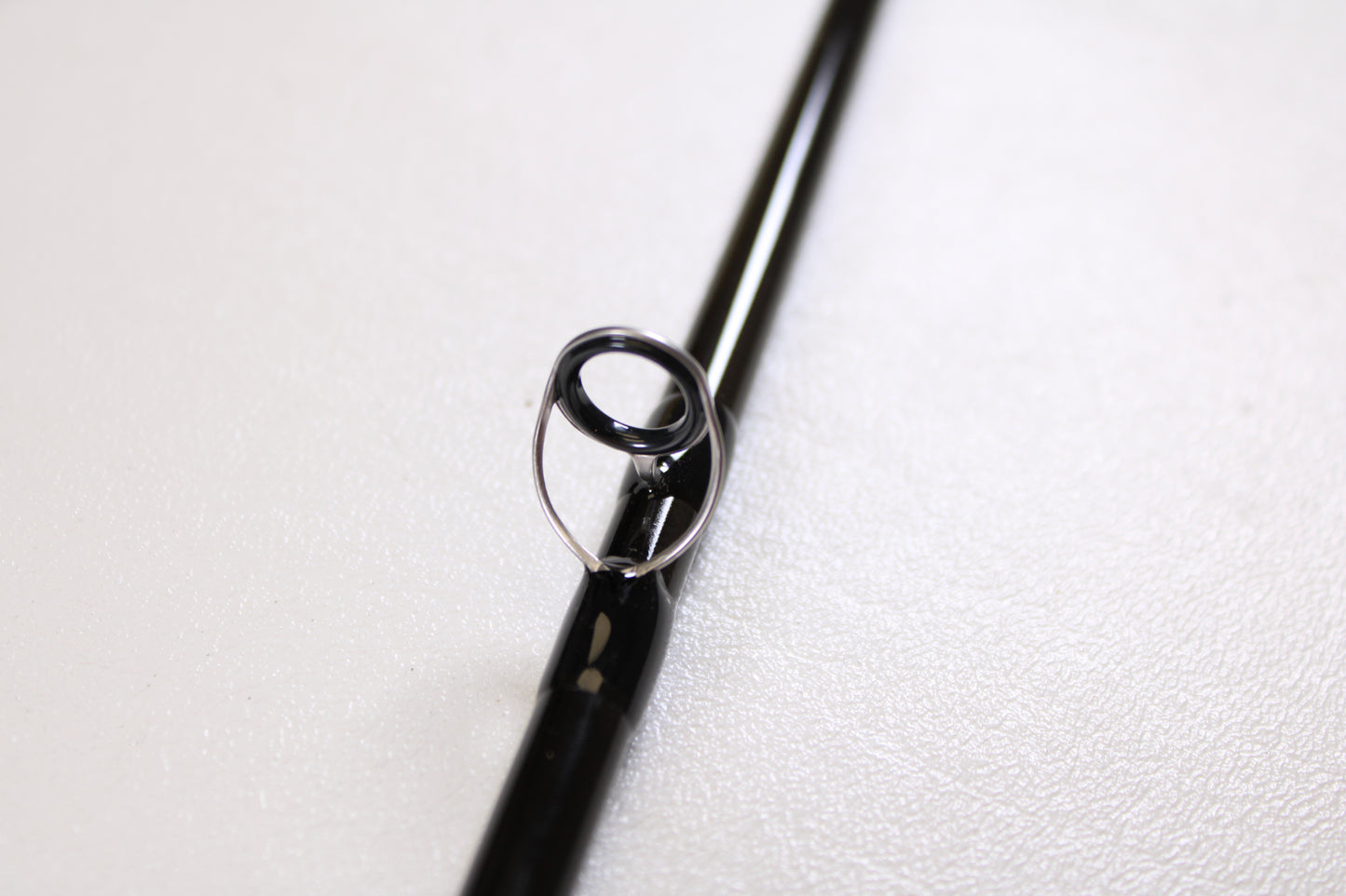 A close-up of a guide ring on the G. Loomis IMX-PRO V2 Fly Rod 490-4 9'0" #4, used but in mint condition—ideal for those interested in G. Loomis quality or our rod and reel trade-in program.