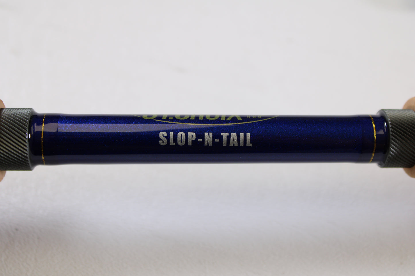 A close-up of a St. Croix Legend Tournament Pike LTPC223HF2 Slop N Tail 7'4" Heavy 2 Piece used casting rod in mint condition, with "SLOP-N-TAIL" printed in white—a great choice for the rod and reel trade-in program.