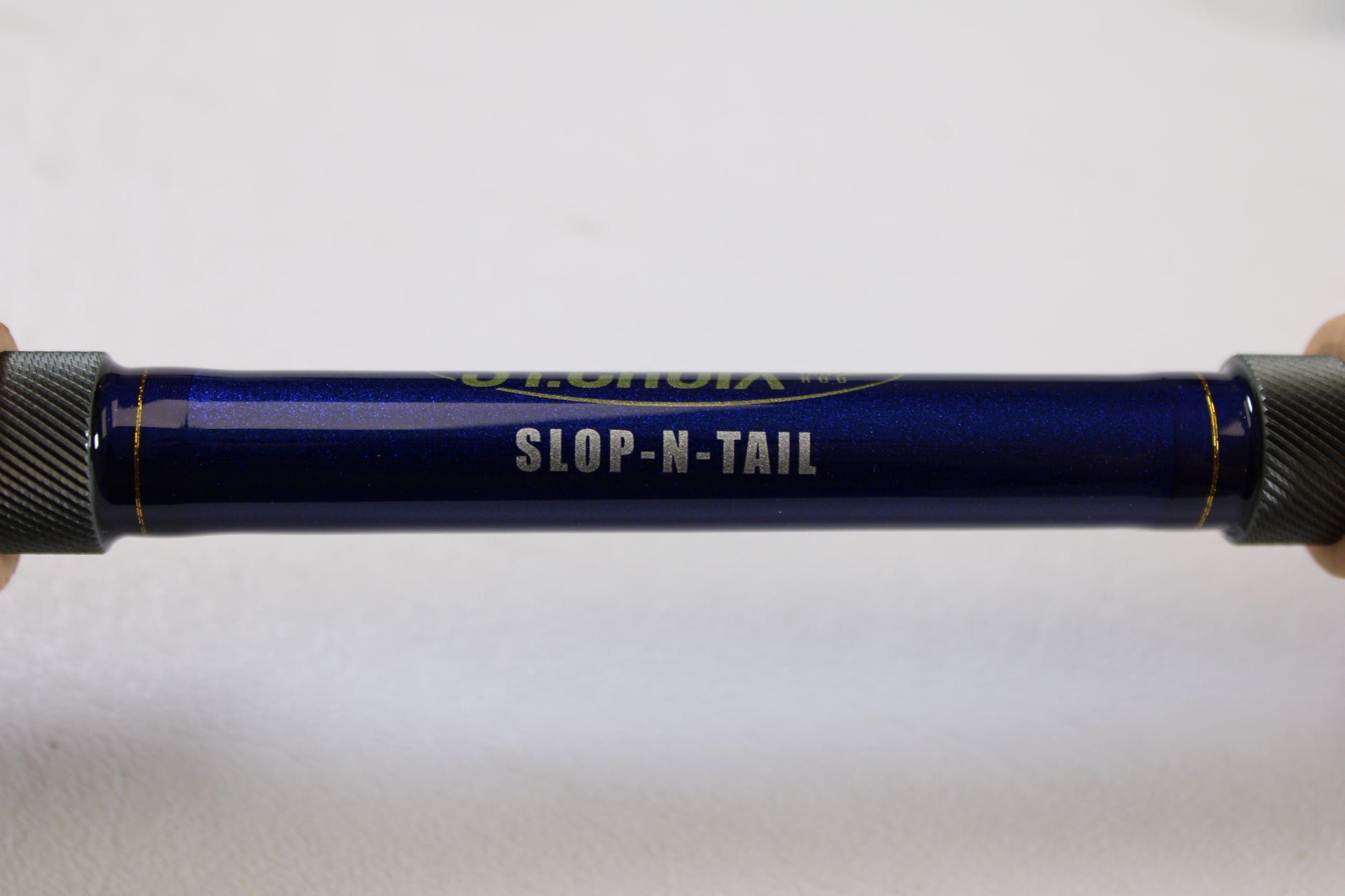 A close-up of a St. Croix Legend Tournament Pike LTPC223HF2 Slop N Tail 7'4" Heavy 2 Piece used casting rod in mint condition, with "SLOP-N-TAIL" printed in white—a great choice for the rod and reel trade-in program.