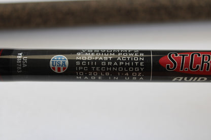 Close-up of a St. Croix Avid Surf VSS90MMF2 9'0" Medium Used Spinning Rod (Mint Condition) with a USA flag emblem. Ask about our trade-in program to earn store credit for your used gear!.