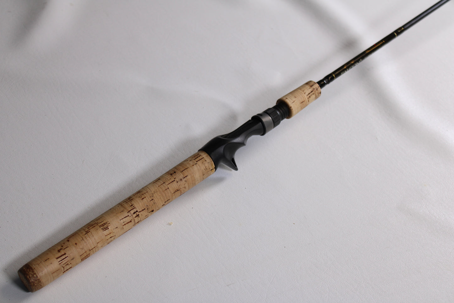 A Falcon Cara T7 CC-4-166M 6'6" Medium Used Casting Rod in very good condition, shown close-up with a cork handle and black reel seat—ideal for those interested in used gear or a rod and reel trade-in.