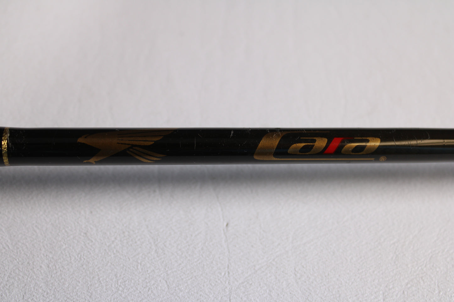 A close-up of a Falcon Cara T7 CC-4-166M 6'6" Medium used casting rod in very good condition, featuring a gold bird logo and "cara" in gold and red—ideal for upgrading via our trade-in program or store credit.
