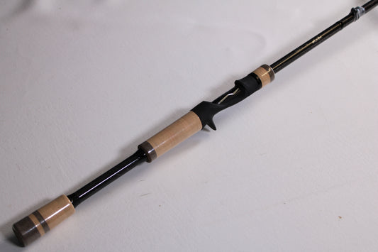 A close-up of the 13 Fishing Envy Black 3 EB3C76MH 7'6" Medium Heavy Casting Rod—used, mint condition—on a plain white surface; ideal for upgrading through our rod and reel trade-in or shopping quality used fishing gear.