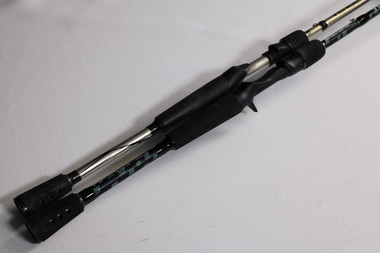 Two Abu Garcia Vengeance 7'0" MH used casting rods with black handles and metallic accents are shown side by side. Part of our Rod and Reel Trade-In Program, both are in good condition with patterned sections near the handles.