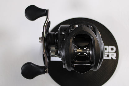 A close-up top view of a Lew's Speed Spool SS1HLA 6.8:1 LH used casting reel in very good condition on a round black mat—ideal for anglers upgrading with our rod and reel trade-in program for store credit.