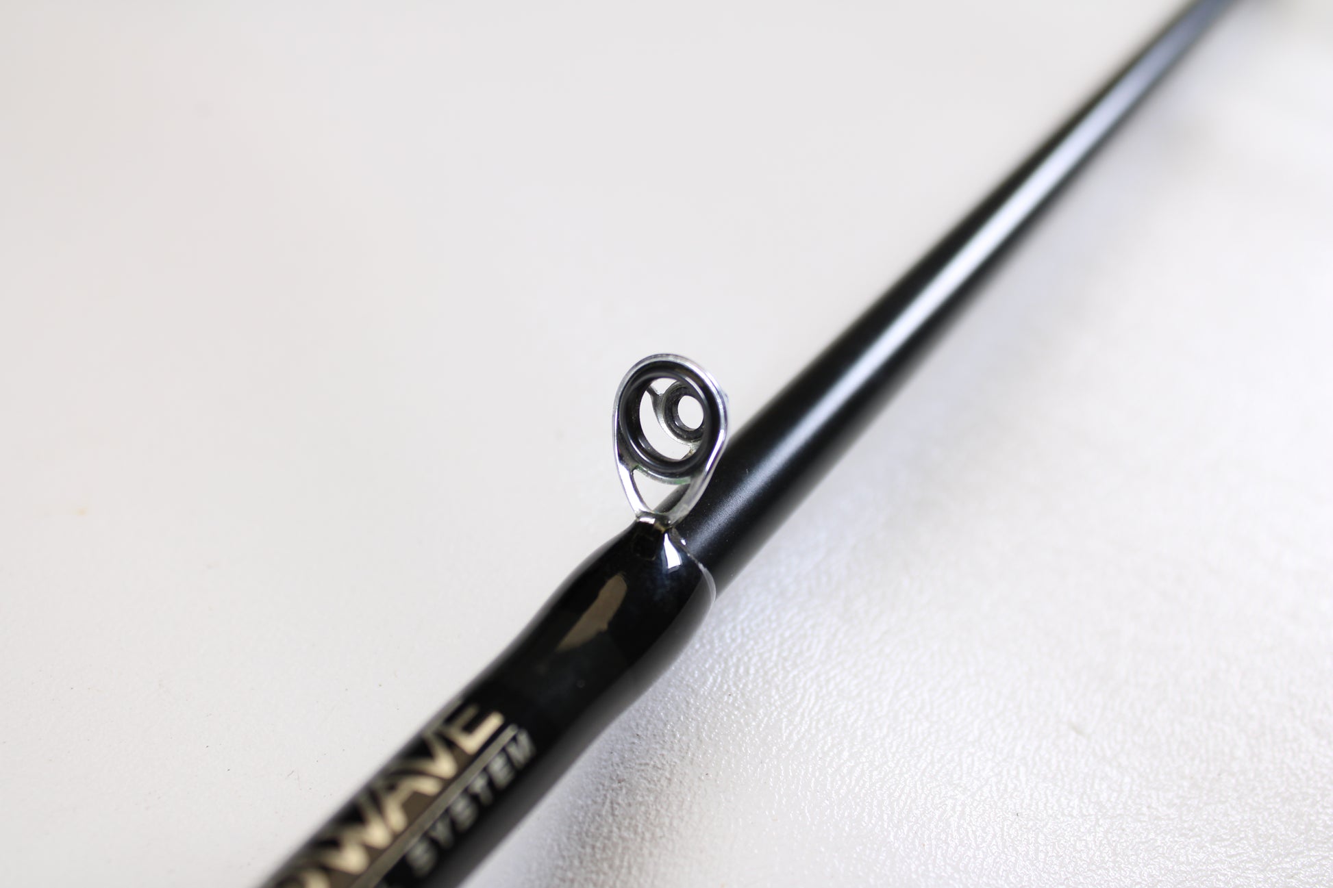 Close-up of a Fitzgerald Original TLR710H Ledge Rod 7’10” Heavy casting rod in very good used condition, focusing on a metal line guide and the shiny black finish—ideal for fishing enthusiasts or our Rod and Reel Trade-In Program.