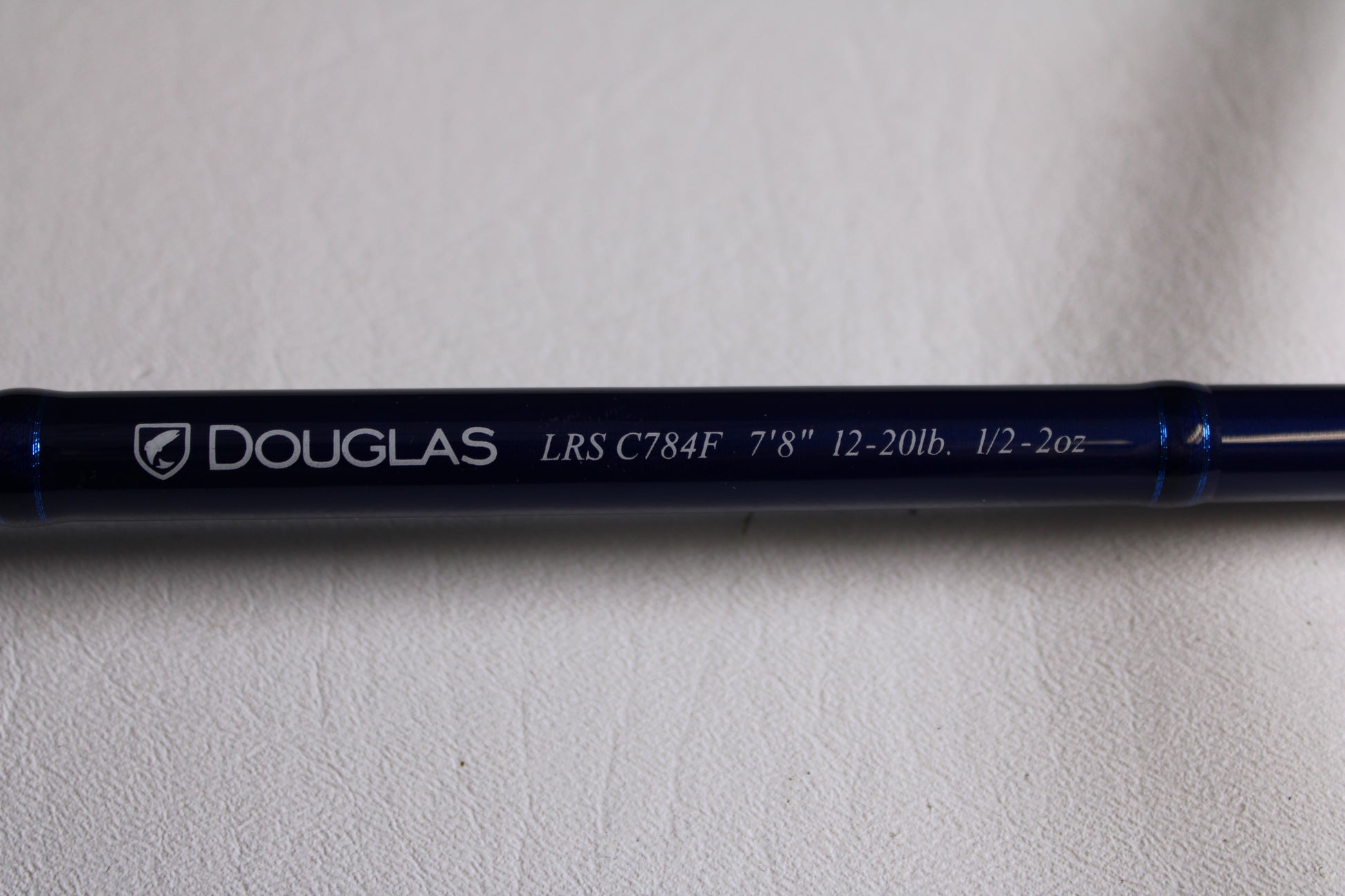 Close-up of a blue Douglas LRS LRSC784F 7'8" Medium Used Casting Rod in excellent condition—ideal for our rod and reel trade-in program or for earning store credit on used gear.
