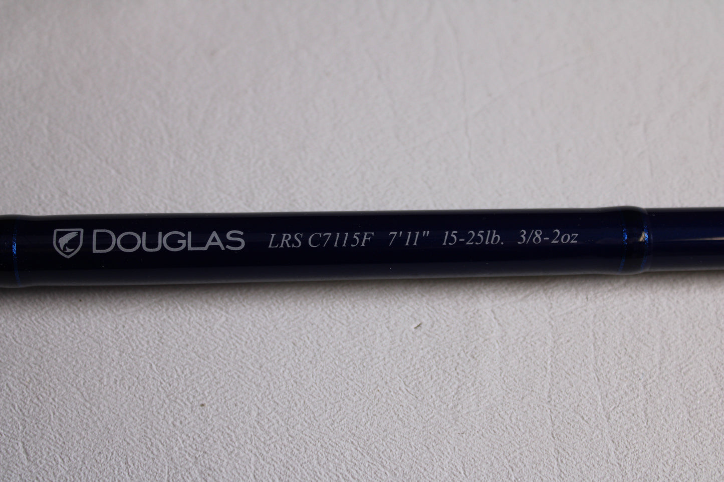 A close-up of a Douglas LRS LRSC7115F 7'11" Heavy Used Casting Rod in excellent condition, showing details on its shaft—ideal for those interested in our Rod and Reel Trade-In Program for store credit.