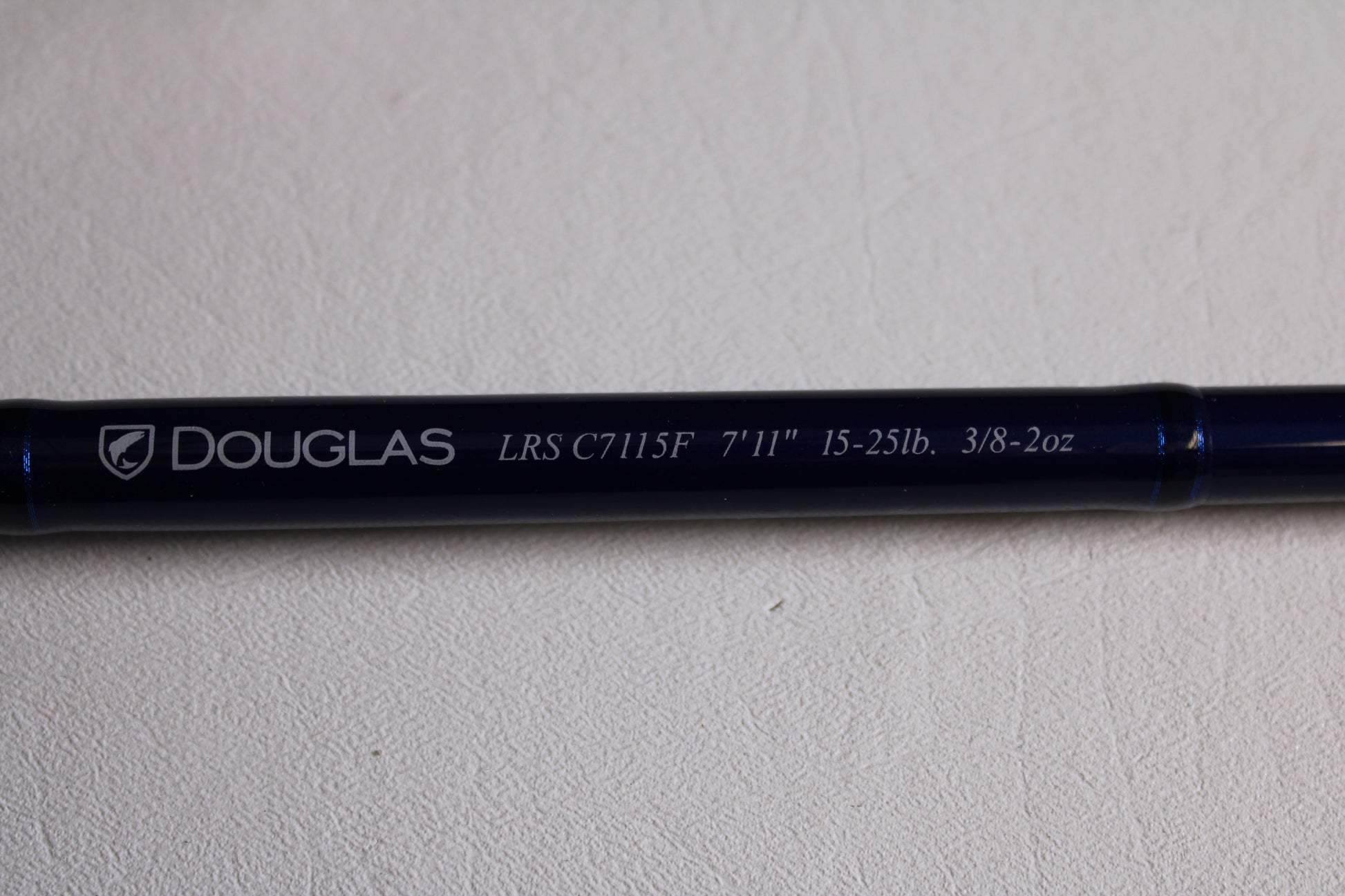 A close-up of a Douglas LRS LRSC7115F 7'11" Heavy Used Casting Rod in excellent condition, showing details on its shaft—ideal for those interested in our Rod and Reel Trade-In Program for store credit.