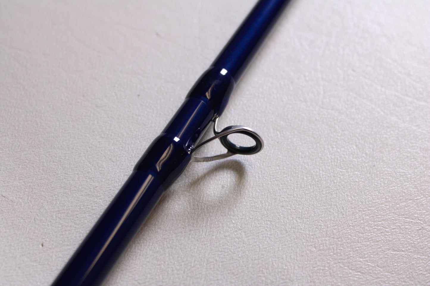 A close-up of the Douglas LRS LRSC7115F 7'11" Heavy Used Casting Rod shows its metal guide ring and fine craftsmanship—an ideal choice for anglers considering our Rod and Reel Trade-In Program for used Douglas fishing gear.