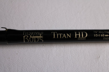 A close-up of a Fitzgerald Titan HD THD76H 7'6" Heavy Used Casting Rod (Very Good Condition) on a white textured background—ideal for our Rod and Reel Trade-In Program if you're upgrading your used gear.
