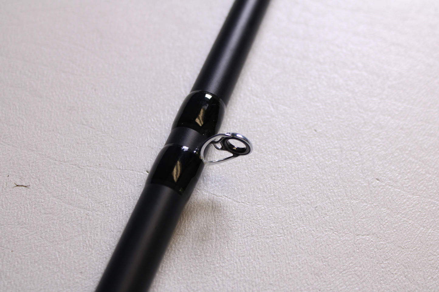 Close-up of the Fitzgerald Titan HD THD76H 7'6" Heavy - Used Casting Rod in very good condition, featuring a shiny silver guide ring—upgrade through our Rod and Reel Trade-In Program and earn store credit for your used Fitzgerald gear.