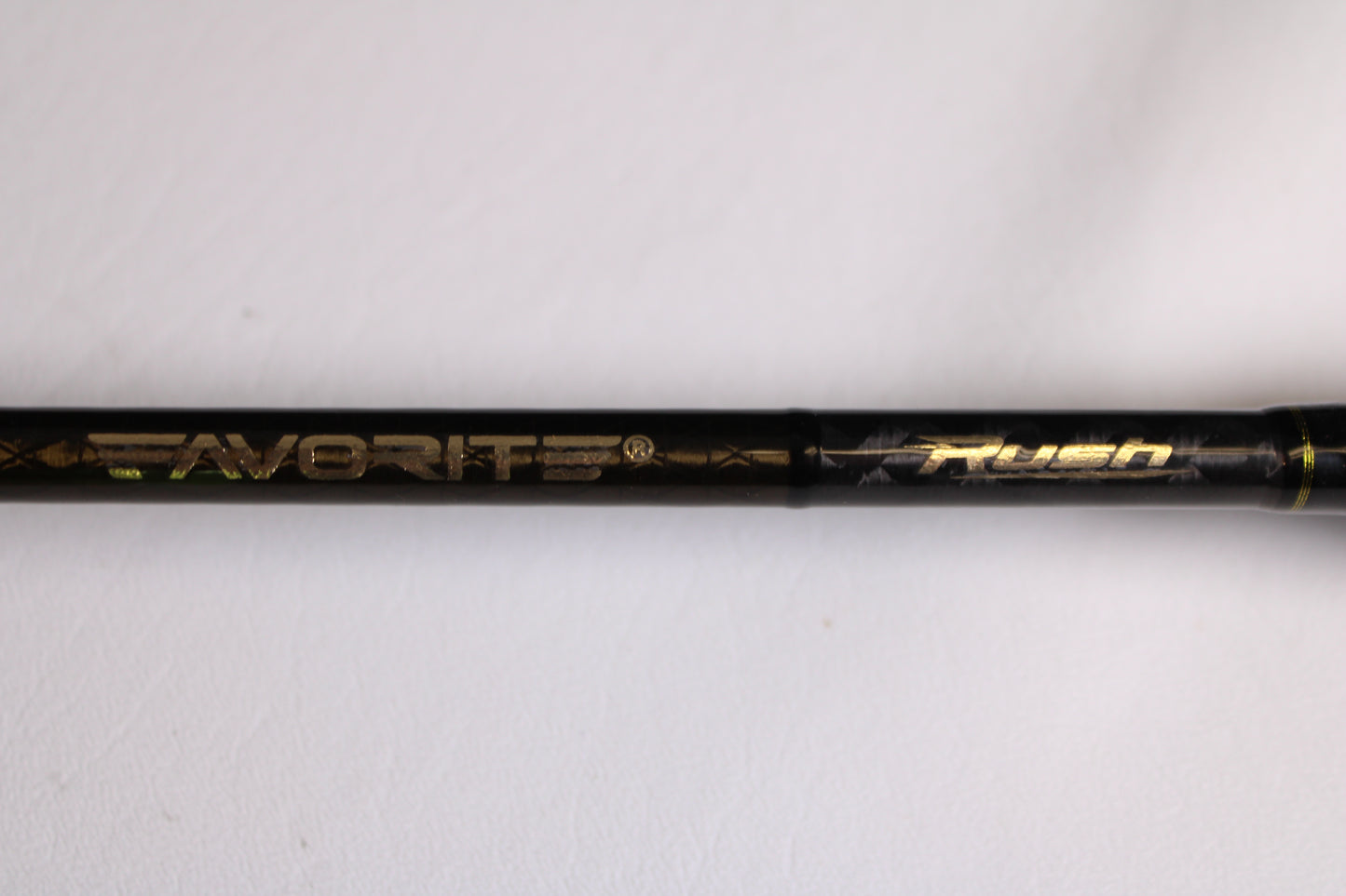 A close-up of the Favorite Fishing Rush RUH-661MH 6'6" Medium Heavy used spinning rod in mint condition, with "Favorite Fishing" and "Rush" in gold lettering, perfect for upgrading your fishing gear or adding to your collection.