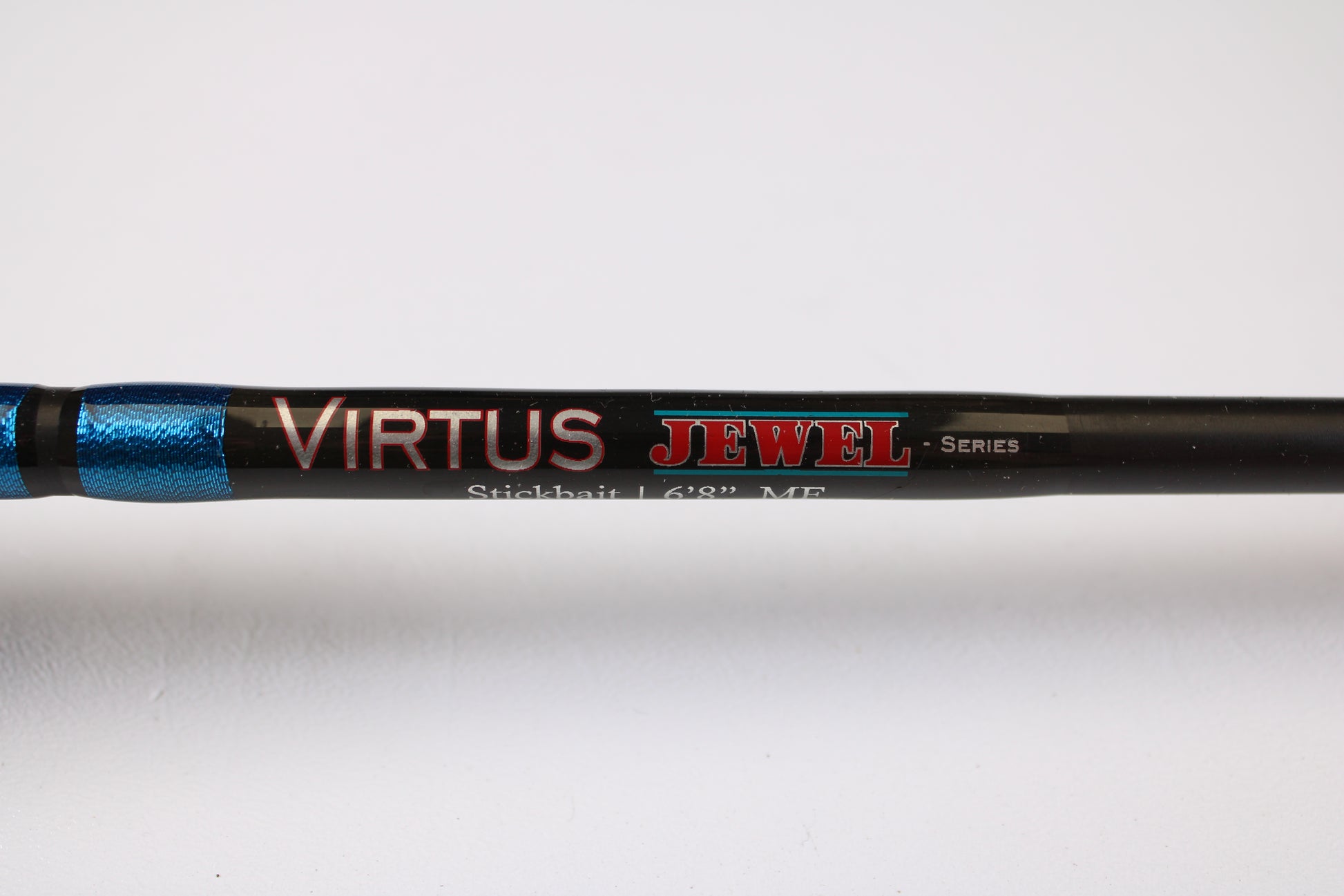 Close-up of a Jewel Virtus Stickbait 6'8" Medium Used Casting Rod in excellent condition, shown in black and metallic blue. Trade in your used gear with our Rod and Reel Trade-In Program for store credit!.