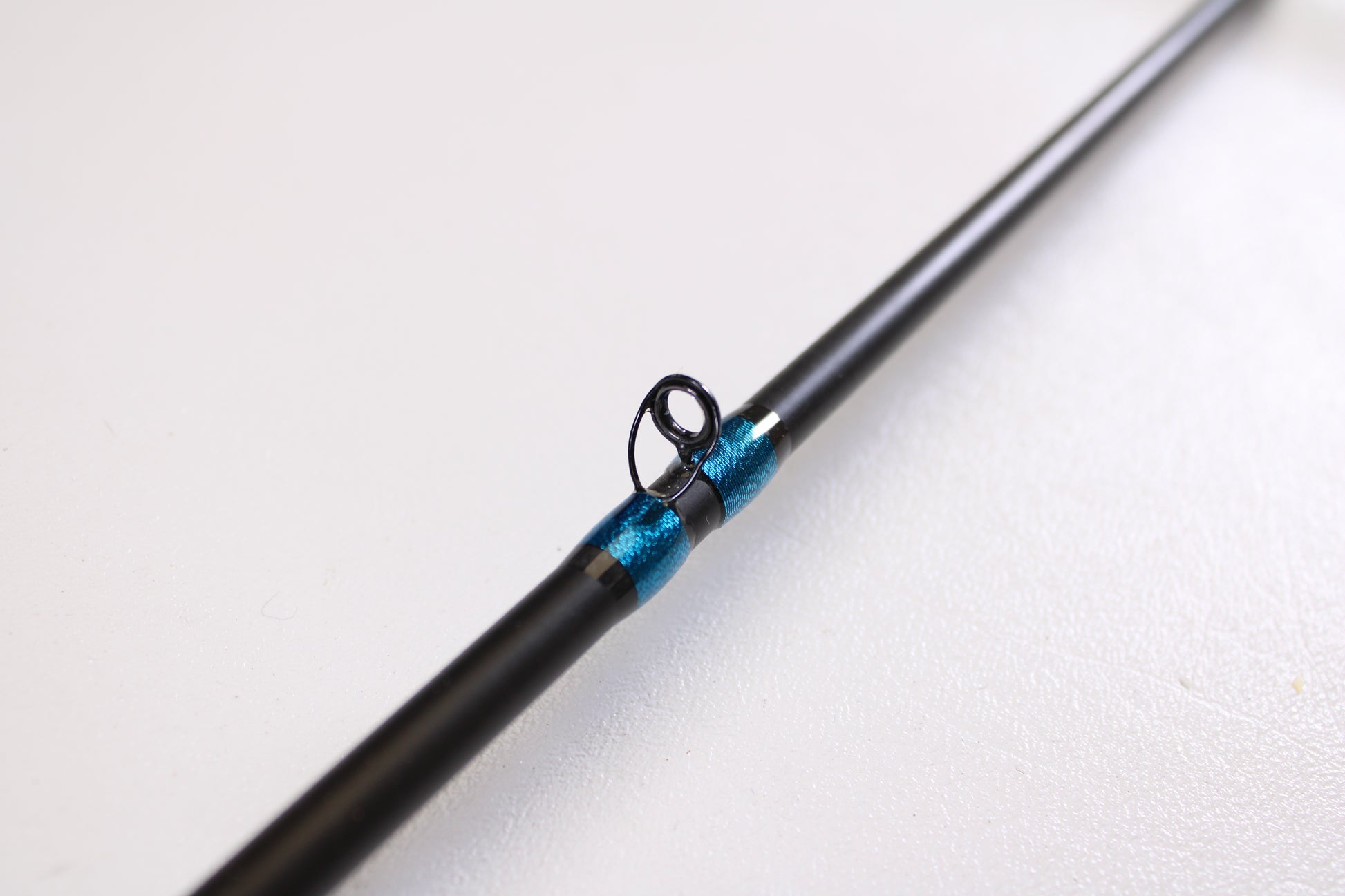 Close-up of the Jewel Virtus Stickbait 6'8" Medium Used Casting Rod in excellent condition, featuring a black finish and blue-wrapped guide ring—ideal for our Rod and Reel Trade-In Program or those wanting to upgrade their gear.