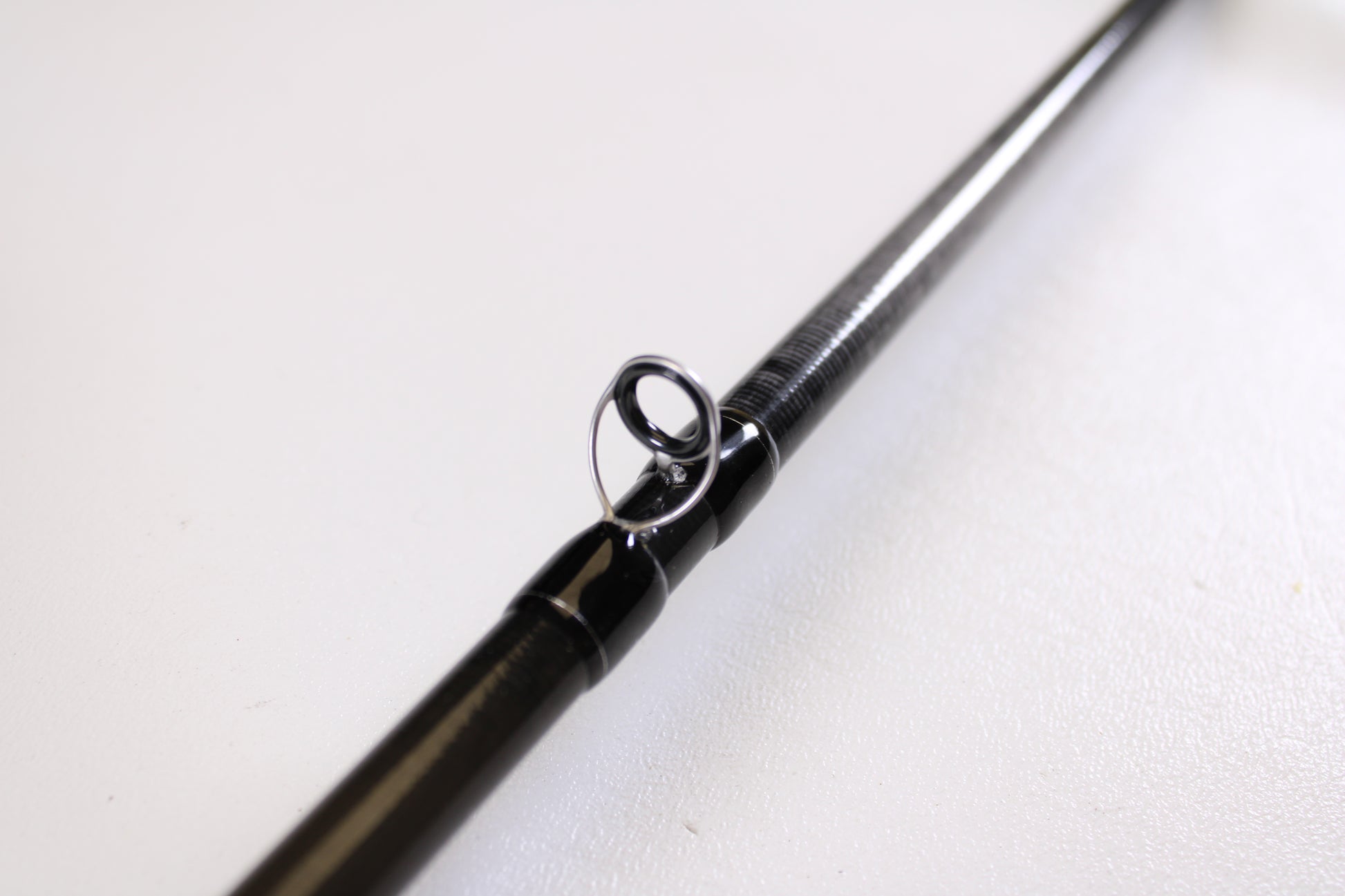 Close-up of the Evergreen Combat Stick RCTC-73MH Jig & Worm 7'3" Medium Heavy—Used Casting Rod in excellent condition, highlighting a metal line guide against a white background—great for those interested in rod trade-ins or used gear.