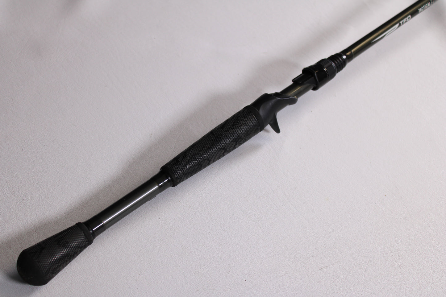 A close-up of the handle and reel seat on a Temple Fork TFO Tactical Elite Bass TLE SB 726-1 7'2" Heavy Used Casting Rod—excellent condition—ideal for anglers seeking quality pre-owned gear from our trade-in program.