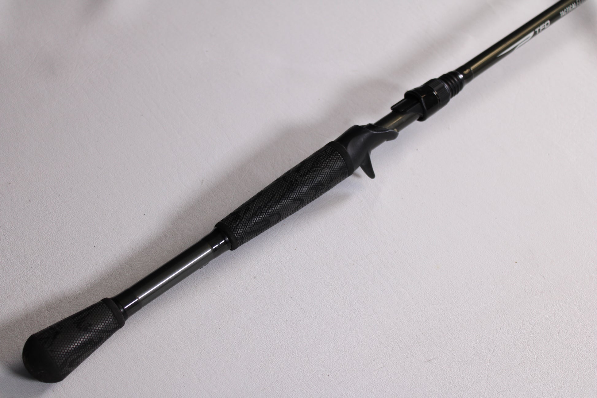 A close-up of the handle and reel seat on a Temple Fork TFO Tactical Elite Bass TLE SB 726-1 7'2" Heavy Used Casting Rod—excellent condition—ideal for anglers seeking quality pre-owned gear from our trade-in program.