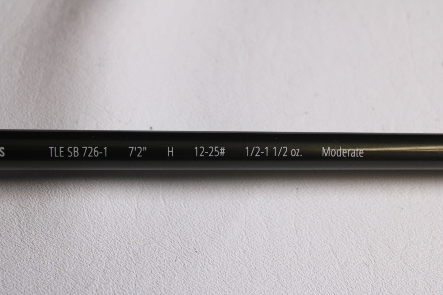 Close-up of a Temple Fork TFO Tactical Elite Bass TLE SB 726-1 7'2" Heavy used casting rod in excellent condition, showing specs: "TLE SB 726-1, 7'2'', H, 12-25#, 1/2-1 1/2 oz., Moderate." Great for rod and reel trade-in or used gear seekers.