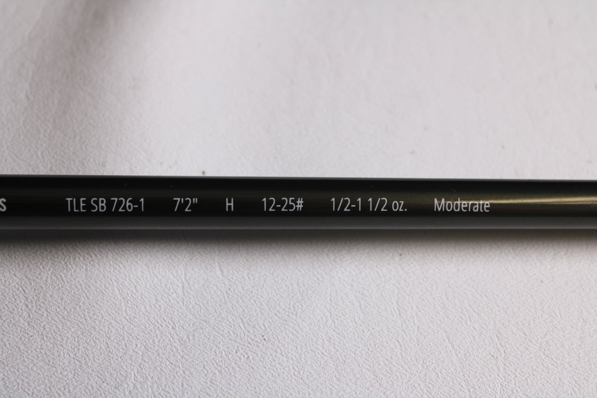Close-up of a Temple Fork TFO Tactical Elite Bass TLE SB 726-1 7'2" Heavy used casting rod in excellent condition, showing specs: "TLE SB 726-1, 7'2'', H, 12-25#, 1/2-1 1/2 oz., Moderate." Great for rod and reel trade-in or used gear seekers.