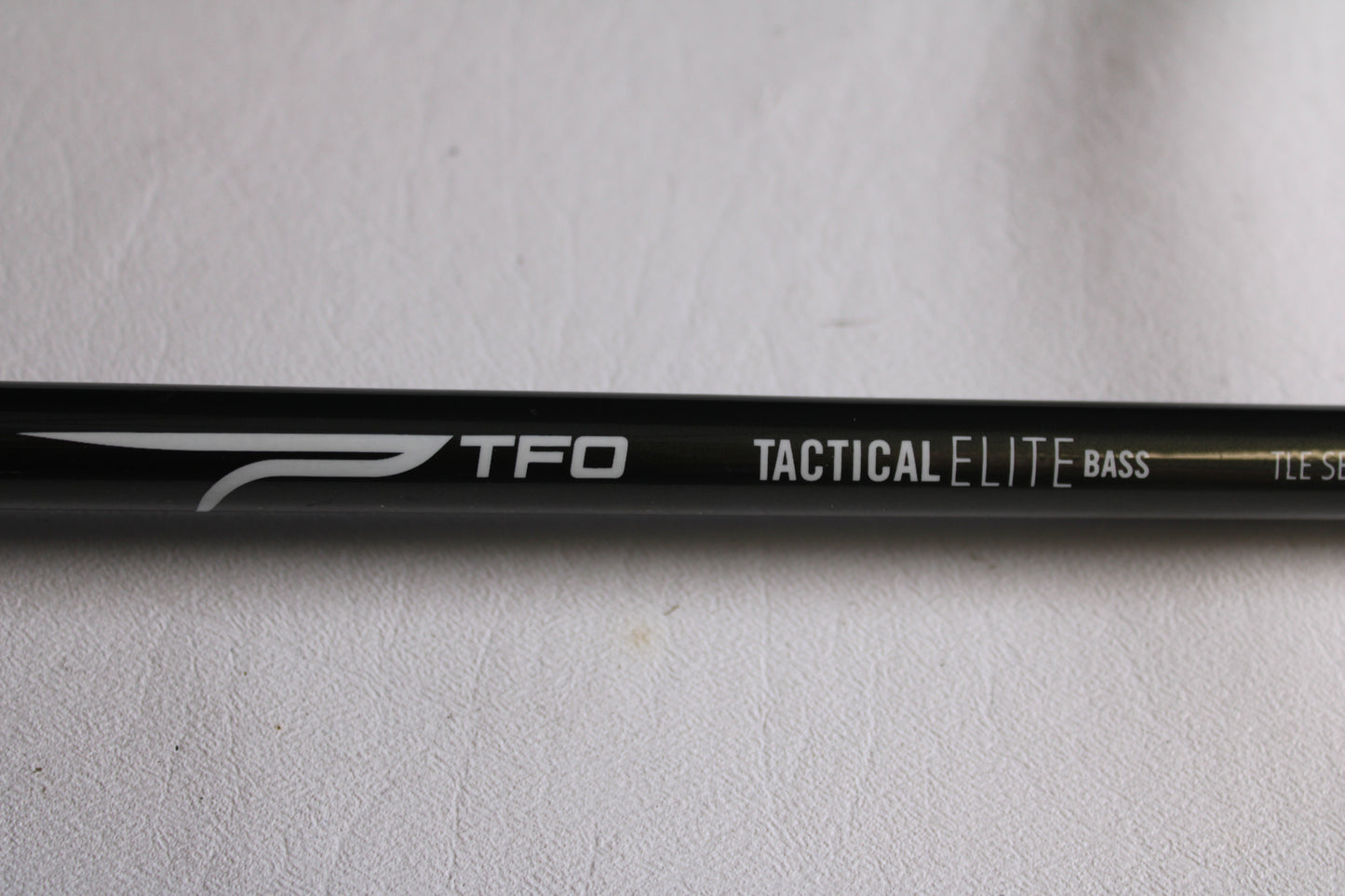 Close-up of a Temple Fork TFO Tactical Elite Bass TLE SB 726-1 7'2" Heavy Used Casting Rod (Excellent Condition) with white text on black—ideal for anglers seeking an upgrade through our rod and reel trade-in program.