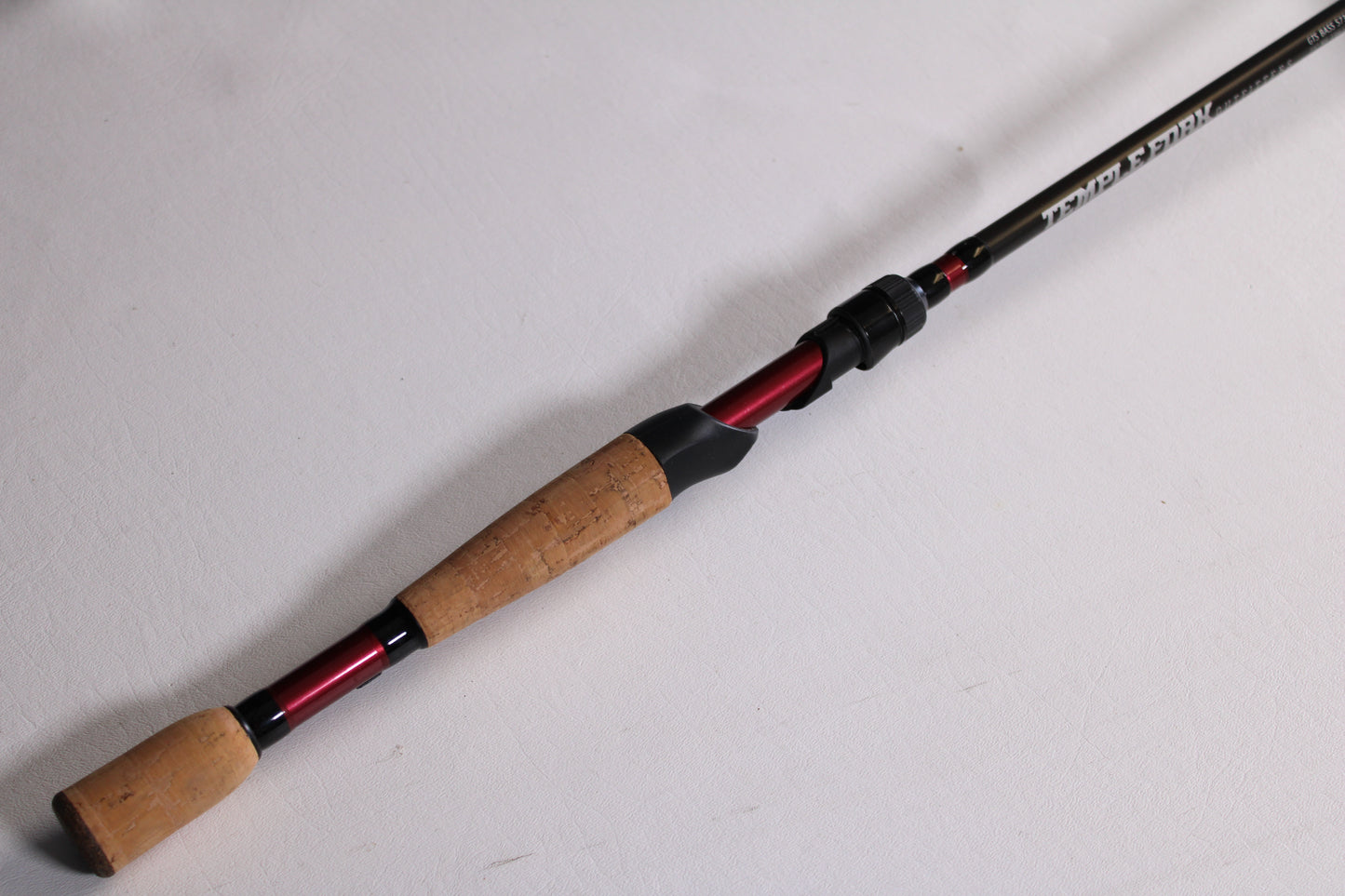 The Temple Fork GTS Bass S735-1 7'3" Medium Heavy Used Spinning Rod (Excellent Condition) features a cork handle and black rod shaft—ideal for those looking to upgrade through our rod and reel trade-in program.