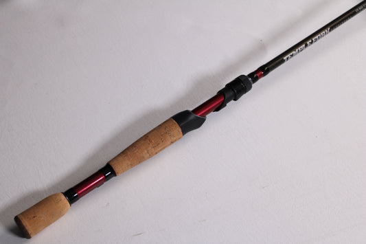 The Temple Fork GTS Bass S735-1 7'3" Medium Heavy Used Spinning Rod (Excellent Condition) features a cork handle and black rod shaft—ideal for those looking to upgrade through our rod and reel trade-in program.