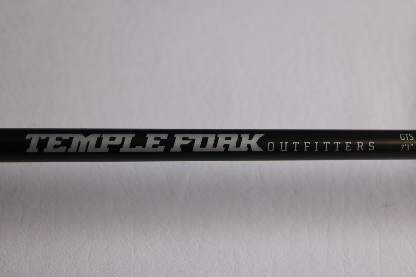 A close-up of the Temple Fork GTS Bass S735-1 7'3" Medium Heavy Used Spinning Rod in excellent condition, shown with white and silver branding—ideal for upgrading through our rod and reel trade-in program for store credit.