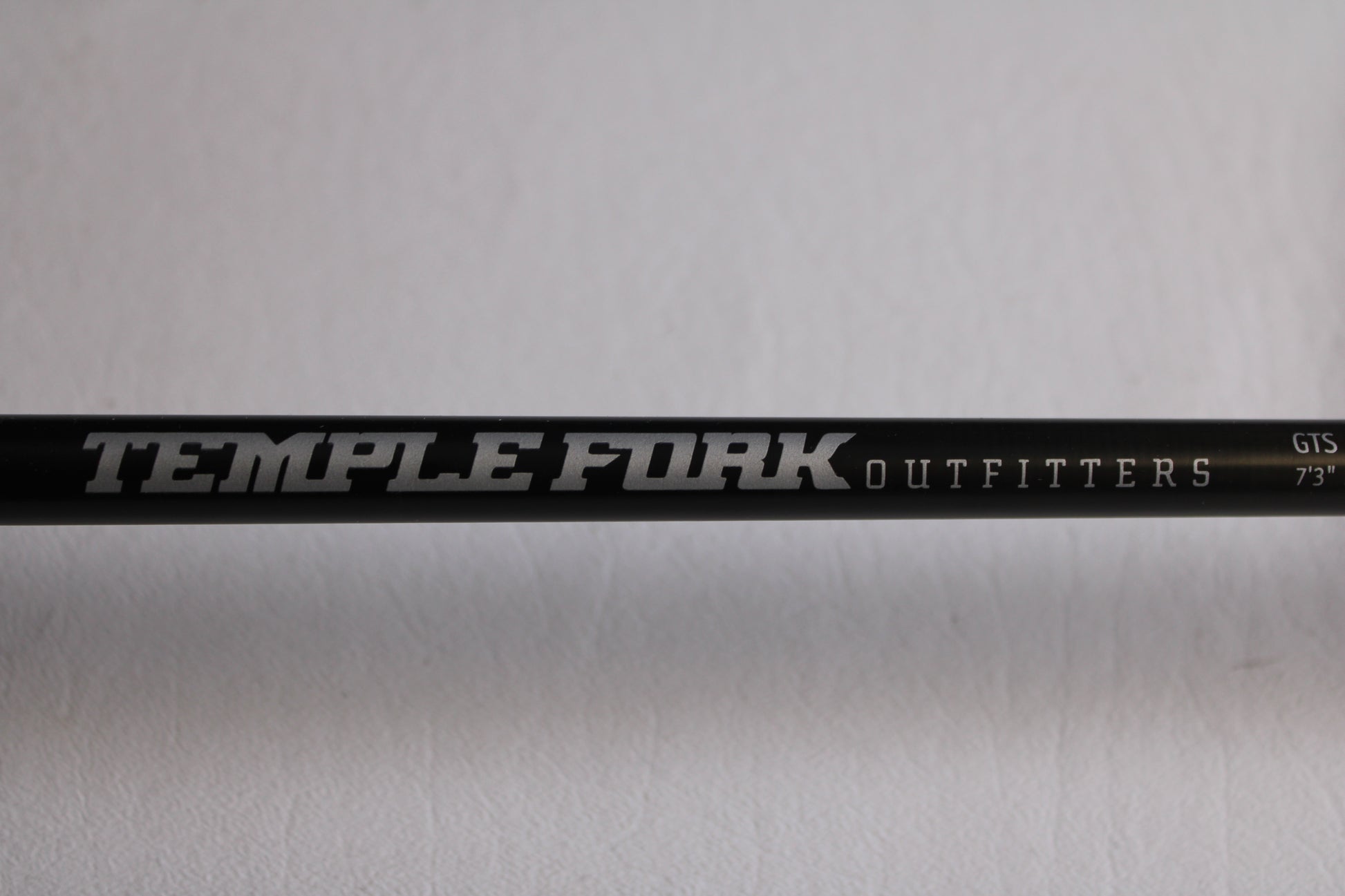 A close-up of the Temple Fork GTS Bass S735-1 7'3" Medium Heavy Used Spinning Rod in excellent condition, shown with white and silver branding—ideal for upgrading through our rod and reel trade-in program for store credit.