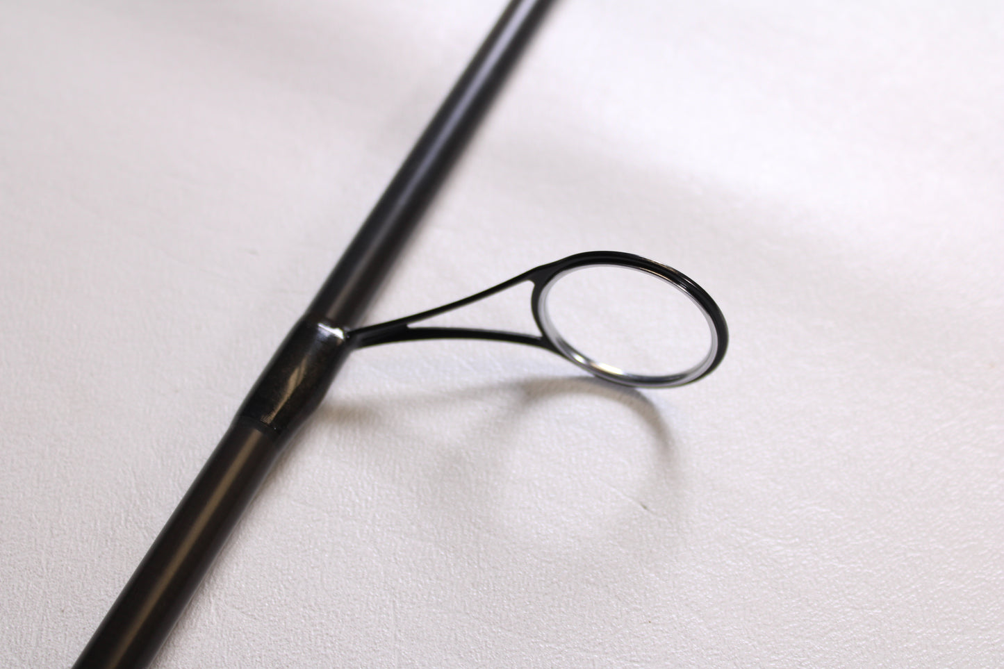A close-up of a Temple Fork Outfitters GTS Bass S735-1 7'3" Medium Heavy used spinning rod guide, showing its smooth, metallic finish and secure attachment against a white background. Brand: Temple Fork. Condition: Excellent.