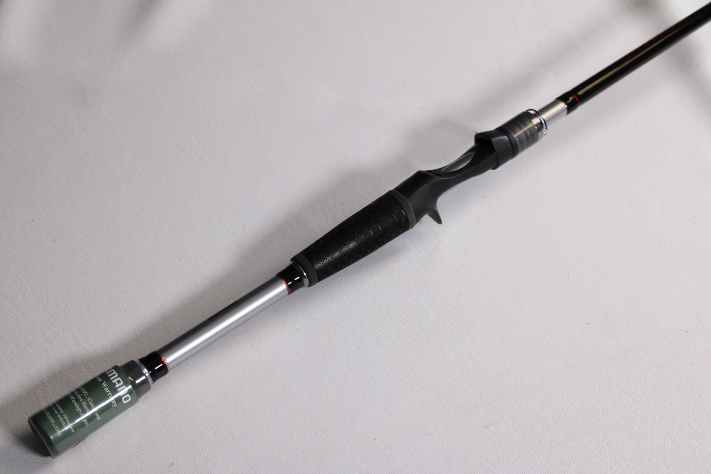 A close-up of a Shimano Intenza NTZC73H 7'3" Heavy used casting rod in mint condition, featuring a black grip and silver reel seat on a white background—ideal for those considering our rod and reel trade-in program.