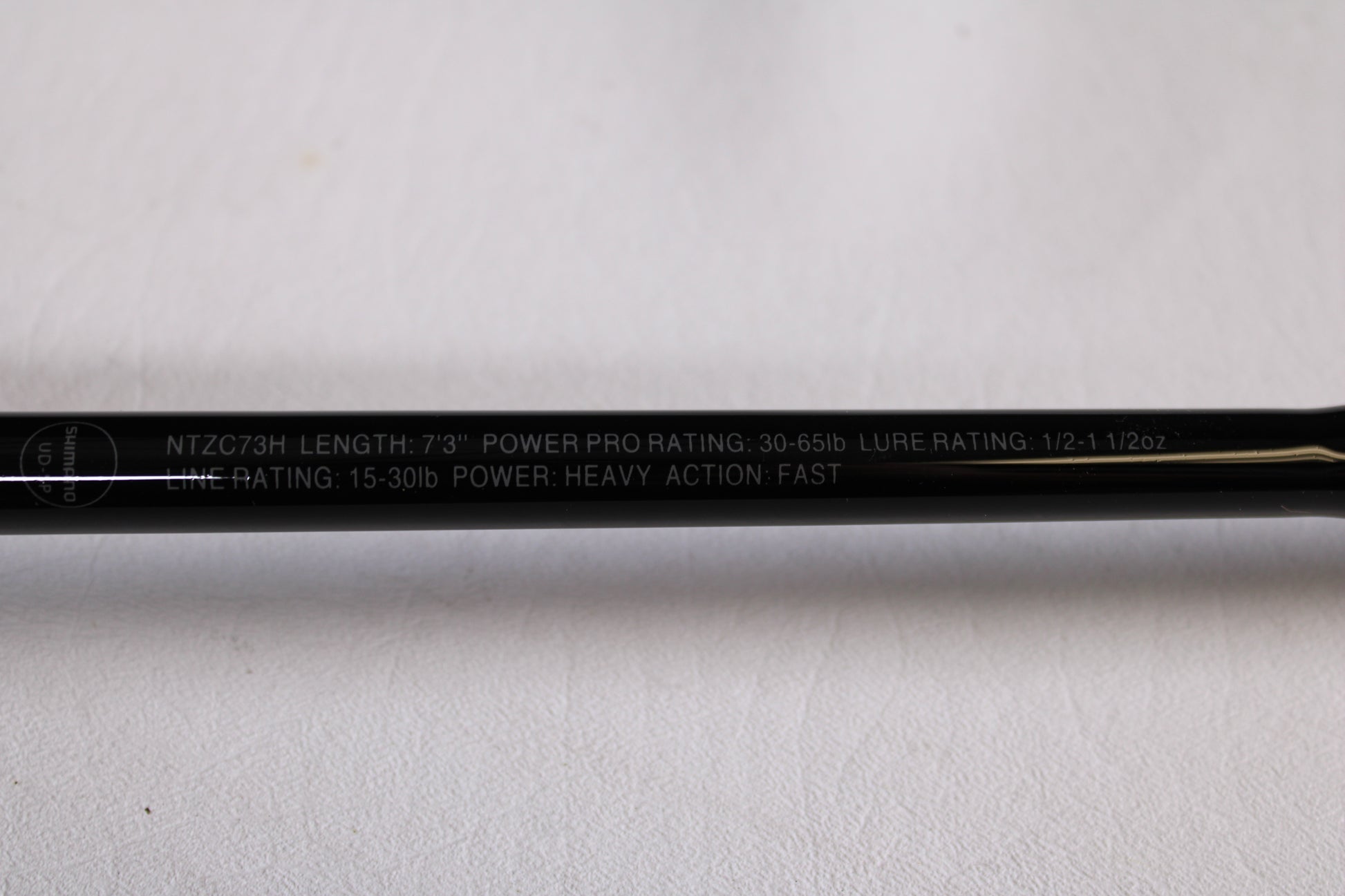 A close-up of the Shimano Intenza NTZC73H 7'3" Heavy Used Casting Rod in mint condition, ideal for our trade-in program. Specs: 30-65lb PowerPro, 1/2–1 1/2oz lure rating, 15-30lb line rating; heavy action, fast power.