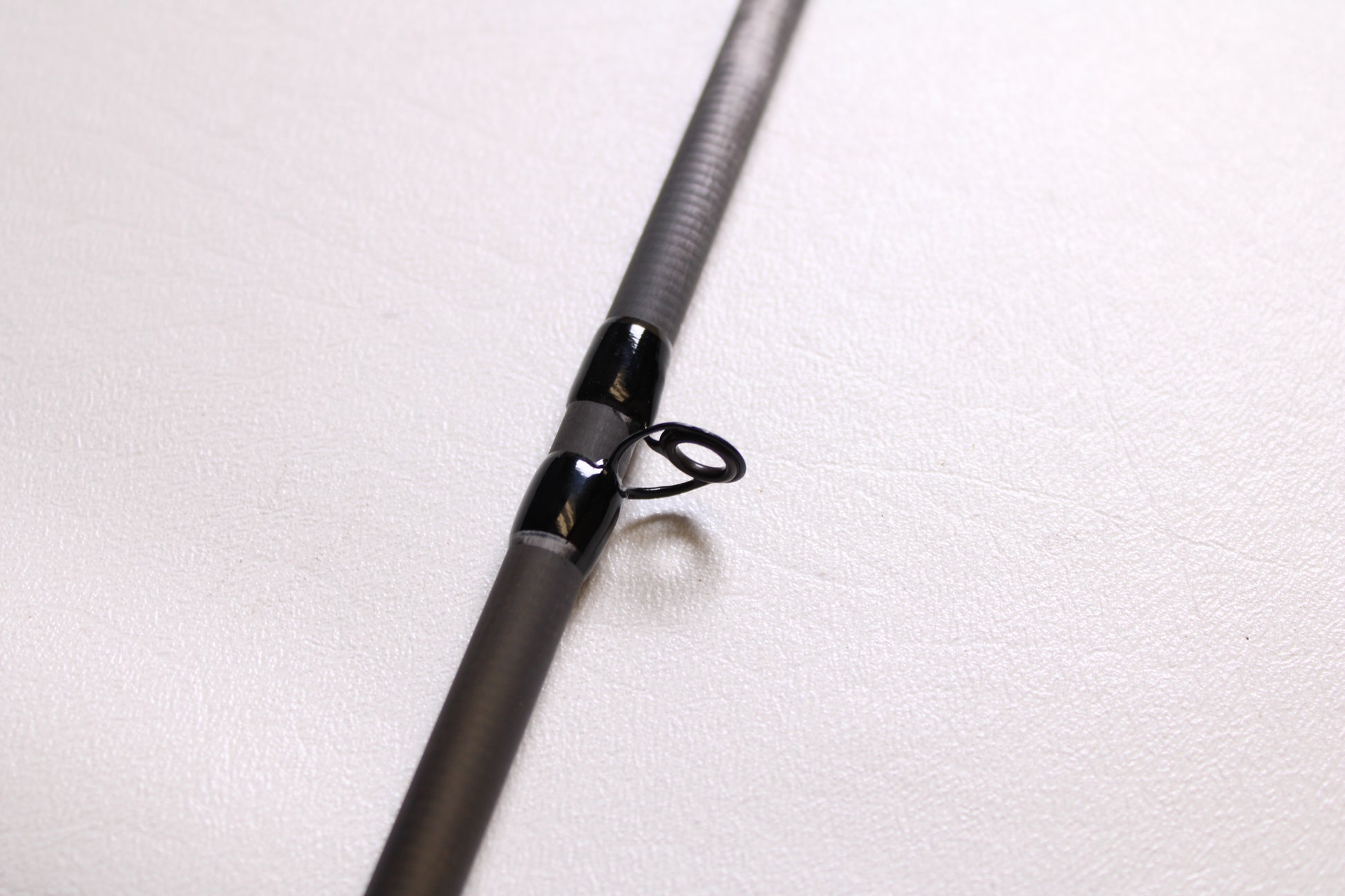 A close-up of a Shimano Intenza NTZC73H 7'3" Heavy Used Casting Rod in mint condition, highlighting the rod guide and shaft—ideal for those interested in our trade-in program to earn store credit for upgrading their gear.