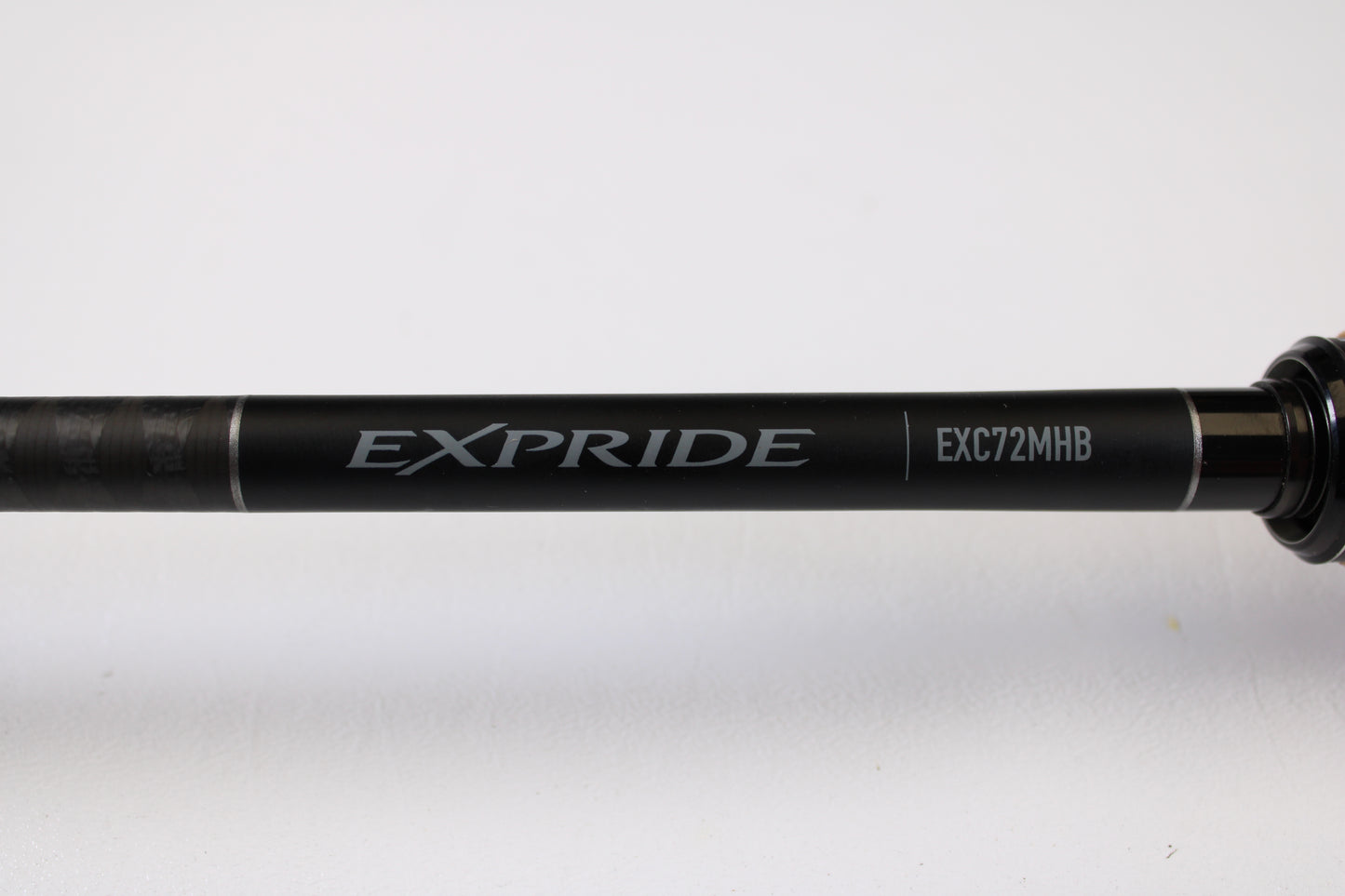 A close-up of a Shimano Expride B EXC72MHB 7'2" Medium Heavy Used Casting Rod in excellent condition, set against a white background—great for those interested in used gear or store credit through our Rod and Reel Trade-In Program.