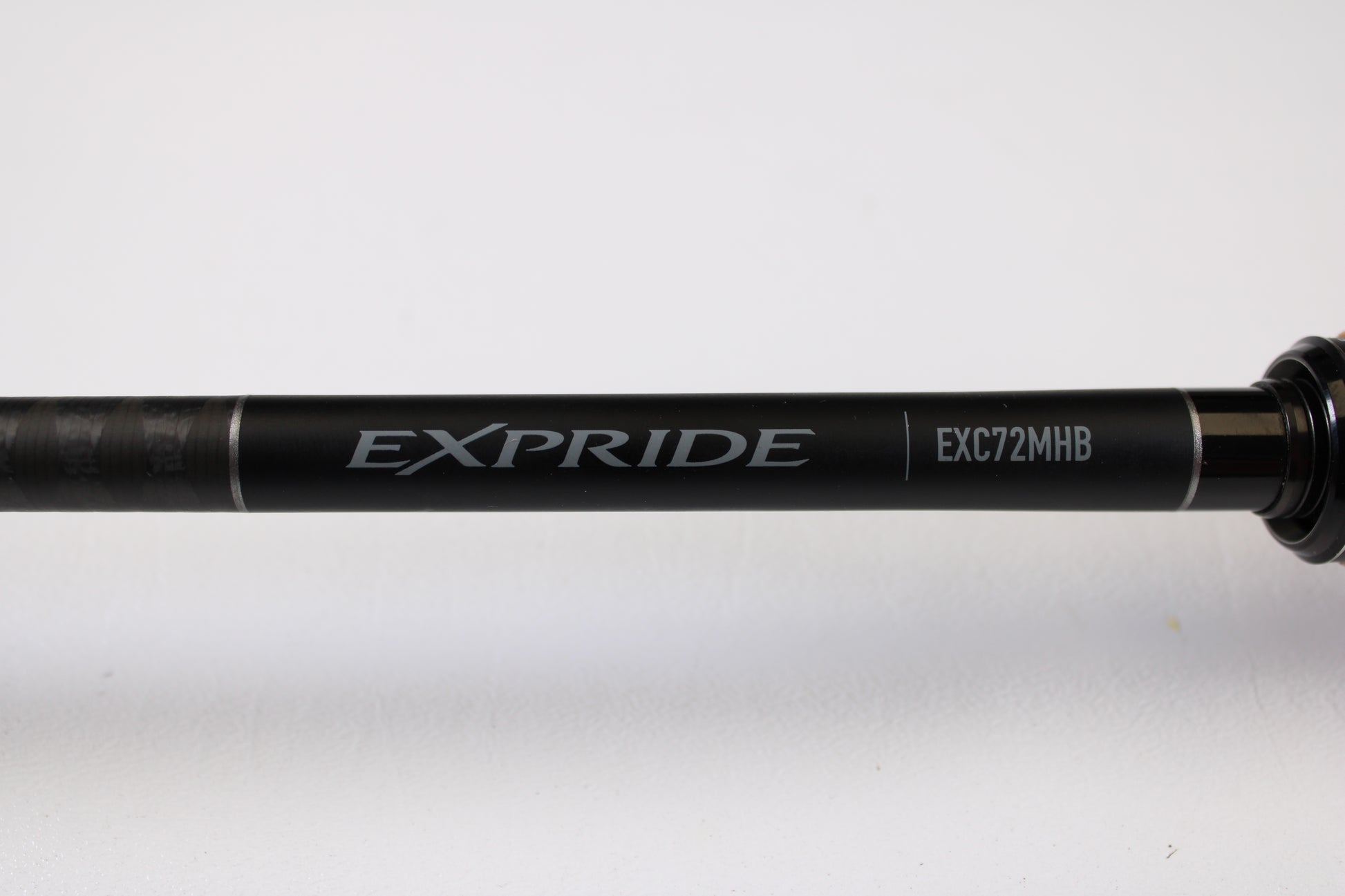 A close-up of a Shimano Expride B EXC72MHB 7'2" Medium Heavy Used Casting Rod in excellent condition, set against a white background—great for those interested in used gear or store credit through our Rod and Reel Trade-In Program.