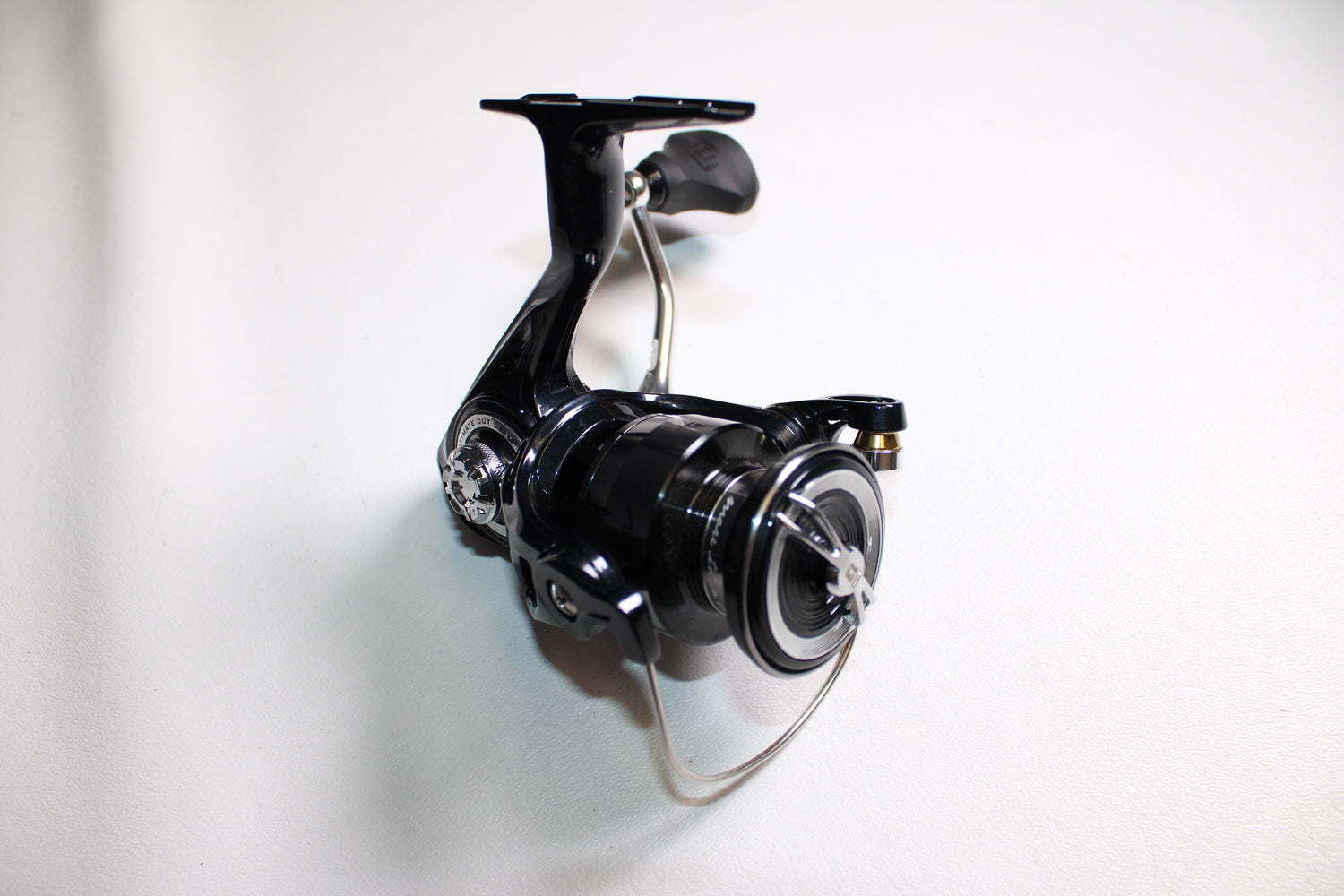 The 13 Fishing Aerios AE-6.2-1.0 Used Spinning Reel by 13 Fishing, in mint condition, is shown on a white surface with its handle, spool, and bail arm highlighted at an angle.