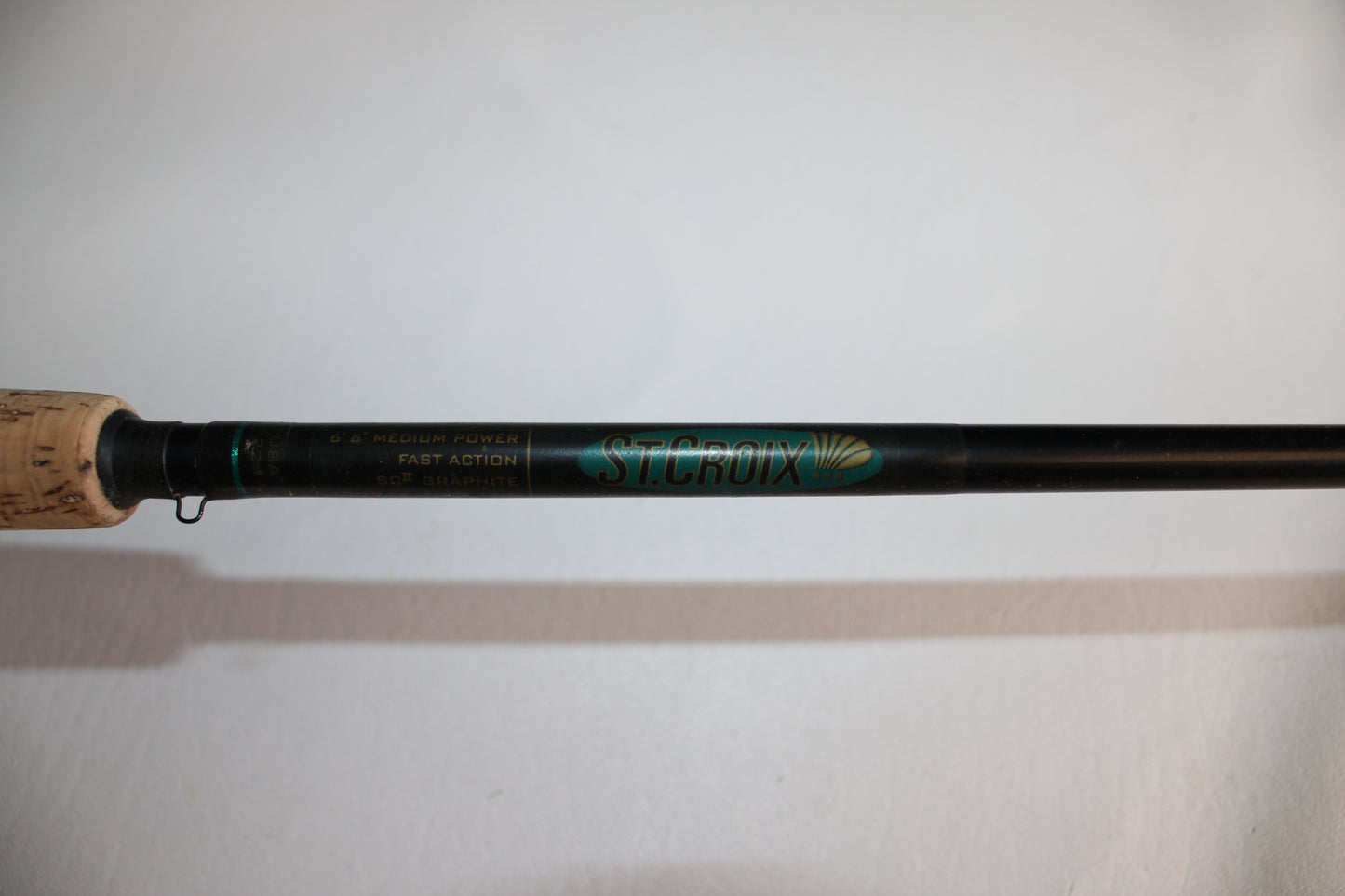 Close-up of the St. Croix Premier PC66MF Used Casting Rod in good condition, showing its cork handle and label with specifications on a white background.