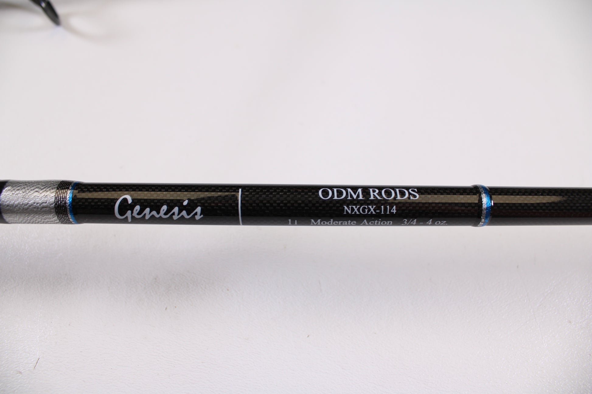 Close-up of the ODM Rods Genesis Surf NGX-114 11'0" 2-Piece Used Spinning Rod in excellent condition, featuring "Moderate Action 3/4 - 4 oz" specs and blue accent rings—ideal for store credit trade-in or used gear listings.
