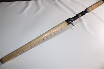 A Shimano SKIXX SKC80XH Used Casting Rod in mint condition, with a light wood handle and black reel seat, is displayed diagonally on a plain white surface—perfect for our rod and reel trade-in program.