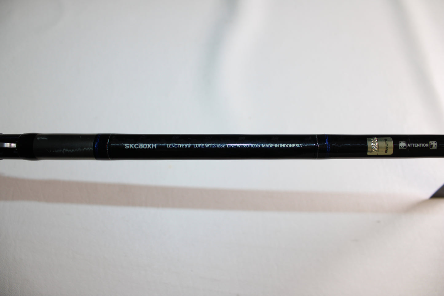 A close-up of a Shimano SKIXX SKC80XH Used Casting Rod in mint condition, showing specs like line weight and "Made in Indonesia" on a white background—ideal for those interested in used rods or our rod and reel trade-in program.