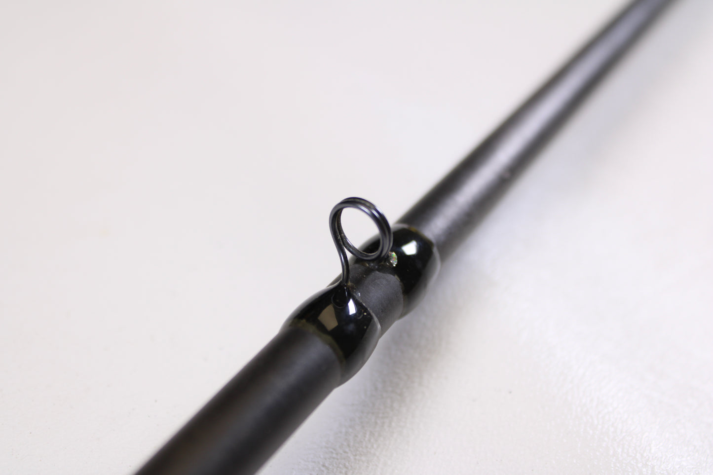 Close-up of a 13 Fishing Envy Black EBC71H 7'1" Heavy Used Casting Rod in very good condition, showing its metal guide ring—ideal for trading in used gear for store credit with our Rod and Reel Trade-In Program.