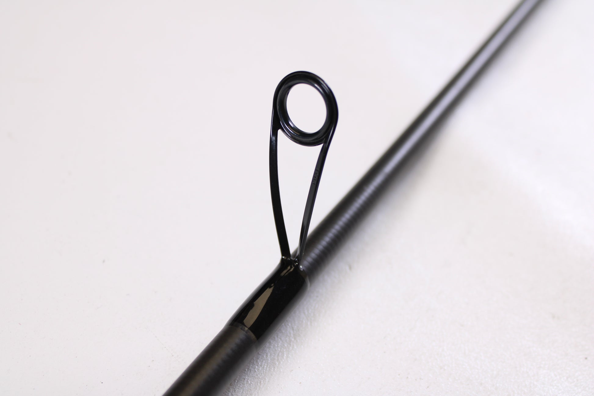 Close-up of the Kistler Helium LTA MIC-HEDSFW70MS 7'0" Medium Used Spinning Rod in very good condition, showing its guide—eligible for trade-in through our Rod and Reel Trade-In Program for store credit.