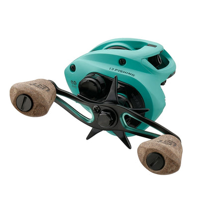 The 13 Fishing Concept TX2 Casting Reel 6.8:1 (TX2-6.8-RH) features a teal low-profile design, two tan cork handles, black star drag control, and visible 13 Fishing branding on the side.