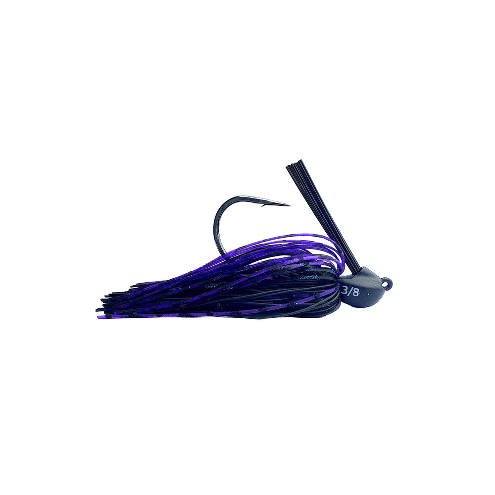 The Beast Coast Lil' Magnum Compact Flipping Tungsten Jig features a weight-forward design with a dark head, curved hook, and purple-black skirt. Its "3/8" marking indicates the weight, and the efficient weed guard angle ensures smooth casting through dense vegetation.